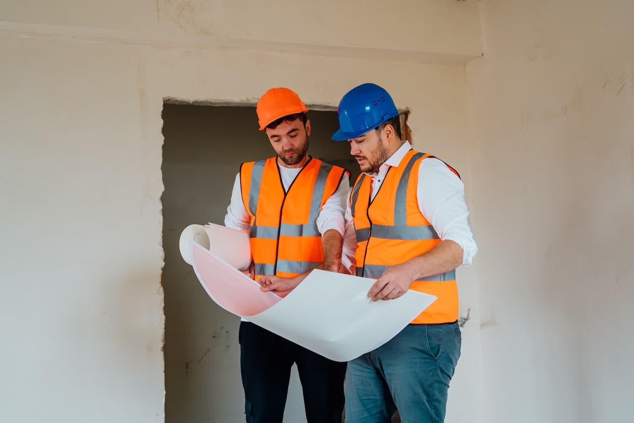Dos técnicos de Iberdeco revisando planos de obra
