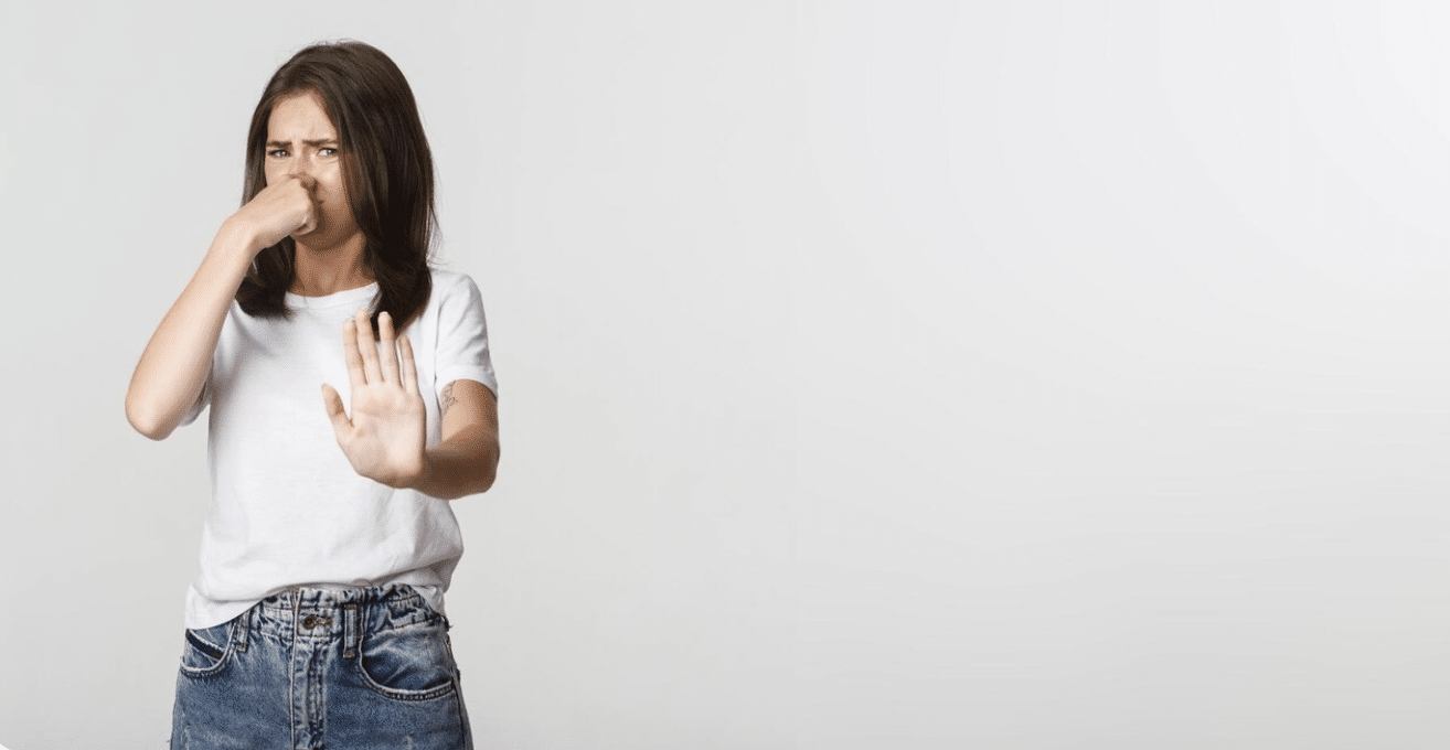 Persona con la mano en la nariz tapándose debido al mal olor por la humedad y moho